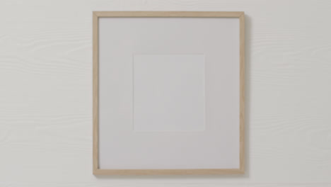 Wooden-frame-with-copy-space-against-white-wall