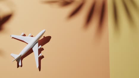 Nahaufnahme-Eines-Weißen-Flugzeugmodells-Und-Kopierraum-Und-Blattschatten-Auf-Gelbem-Hintergrund