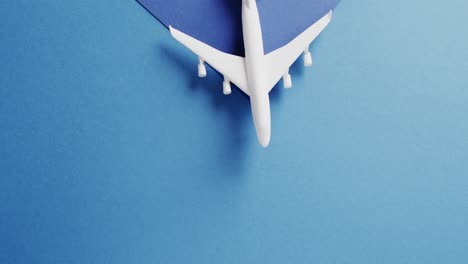 Close-up-of-white-airplane-model-and-copy-space-on-blue-background