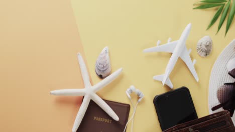 Nahaufnahme-Von-Muscheln,-Reisepass,-Flugzeugmodell,-Smartphone-Mit-Kopierraum-Auf-Gelbem-Hintergrund