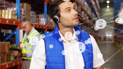 Animation-of-network-of-digital-icons-on-caucasian-male-supervisor-using-digital-tablet-at-warehouse