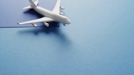 Close-up-of-white-airplane-model-and-copy-space-on-blue-background