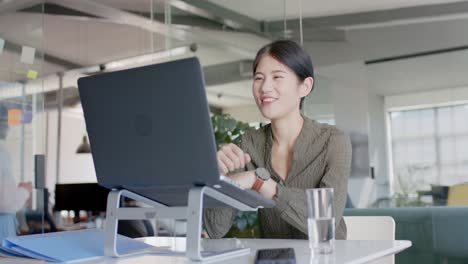 Fröhliche-Asiatische-Geschäftsfrau-Mit-Laptop-Videoanruf-Im-Büro-In-Zeitlupe