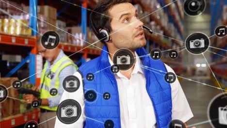 Animation-of-network-of-digital-icons-on-caucasian-male-supervisor-using-digital-tablet-at-warehouse