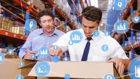 Animation-of-network-of-digital-icons-on-two-caucasian-male-supervisors-checking-boxes-at-warehouse