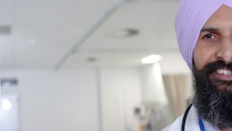 Portrait-of-biracial-sikh-male-doctor-in-turban-at-hospital,-copy-space,-in-slow-motion