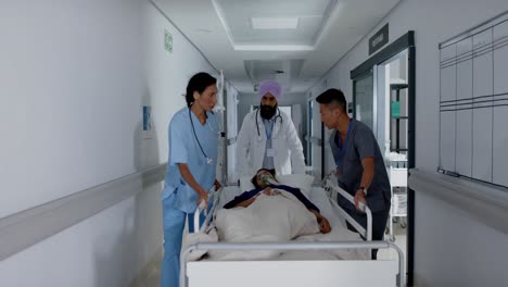 Busy-diverse-doctor-and-surgeons-walking-with-patient-on-hospital-bed-in-slow-motion