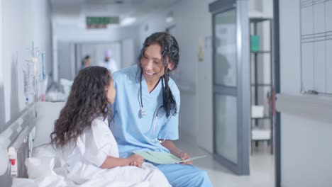 Diversa-Doctora-Y-Paciente-Infantil-Hablando-En-El-Pasillo-Del-Hospital,-En-Cámara-Lenta
