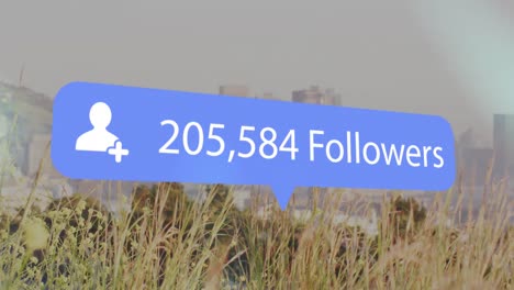 Animation-of-changing-numbers,-followers-text-in-notification-icon-over-grass-against-city