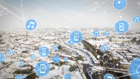 Animation-of-icons-connected-with-lines-over-aerial-view-of-snow-covered-city-against-sky