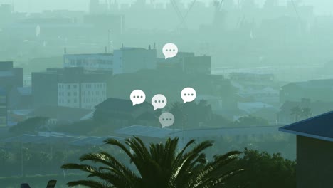 Animation-of-message-icons-floating-against-aerial-view-of-cityscape