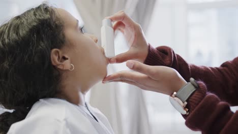 Biracial-mother-using-inhaler-on-her-daughter-in-hospital-in-slow-motion