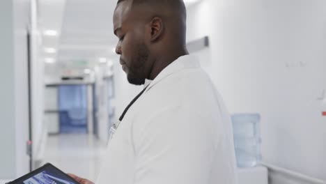 Busy-diverse-doctors-using-tablet-and-talking-in-hospital-in-slow-motion