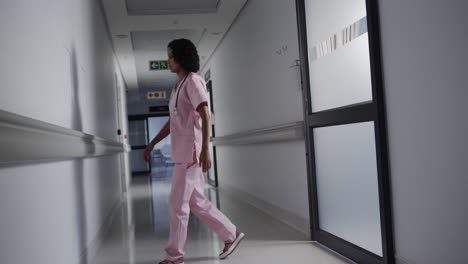 Enfermera-Birracial-Estresada-Apoyada-En-La-Pared-Del-Hospital-En-Cámara-Lenta