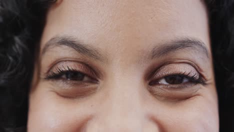 Close-up-of-portrait-of-happy-biracial-woman-looking-at-camera-in-slow-motion