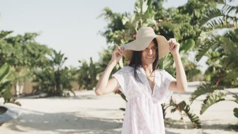 Happy-hispanic-woman-in-sunhat-and-sundress-smiling-on-sunny-beach,-slow-motion