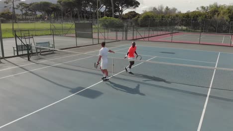 Verschiedene-Männliche-Tennisspieler-Halten-Schläger-In-Der-Hand-Und-Schütteln-Sich-Auf-Dem-Platz-Die-Hände