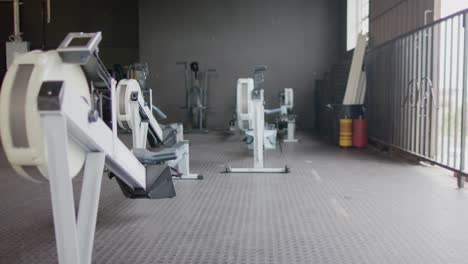 General-view-of-empty-fitness-room-at-gym-with-exercise-equipment,-in-slow-motion