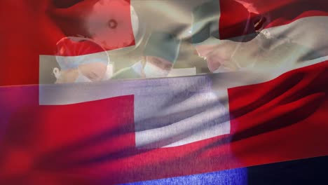 Animation-of-flag-of-switzerland-over-caucasian-surgeons-with-face-masks-during-surgery