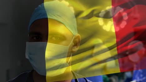 Animation-of-waving-belgium-flag-against-african-american-male-surgeon-at-hospital