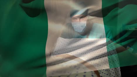 Animation-of-nigeria-flag-over-caucasian-male-surgeon-operating-pregnant-woman-during-delivery