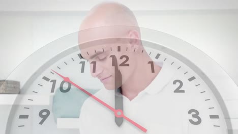 Animation-of-clock-ticking-over-caucasian-businessman-using-tablet