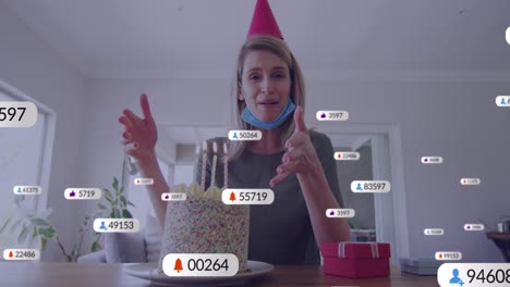 Animation-of-social-media-icons-with-numbers-over-caucasian-woman-having-birthday-video-call