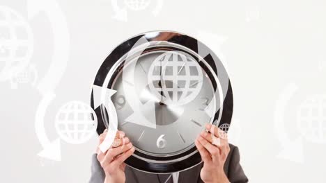 Animation-of-globes-and-arrows-icons-over-caucasian-man-holding-clock