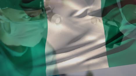 Animation-Des-Schwenkens-Der-Nigeria-Flagge-Gegen-Verschiedene-Männliche-Und-Weibliche-Chirurgen,-Die-Eine-Operation-Durchführen