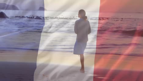 Animation-Der-Flagge-Frankreichs-über-Einer-Kaukasischen-Frau,-Die-Am-Strand-Spaziert