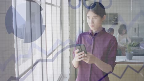 Animation-of-financial-data-processing-over-asian-businesswoman-using-smartphone-at-office