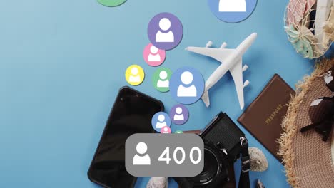 Animation-of-social-media-icons-with-numbers-over-travel-equipment-on-blue-background