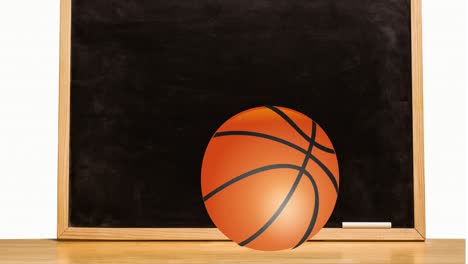 Animation-of-basketball-rolling-on-table-over-black-board-and-white-chalk-against-white-background