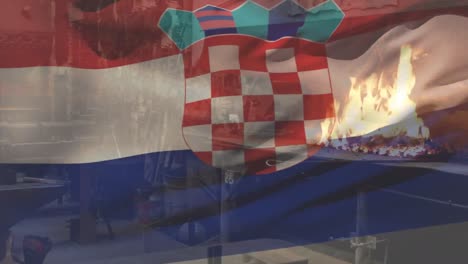 Animation-of-croatian-flag-waving-over-fire-burning-on-barbecue-grill-at-commercial-restaurant