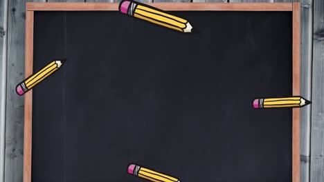 Animation-of-pencils-falling-over-black-board-with-copy-space