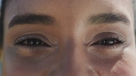 Portrait-close-up-of-eyes-of-happy-biracial-woman-smiling-in-the-sun,-in-slow-motion