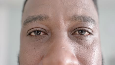 Unaltered-portrait-of-happy-african-american-male-doctor-opening-eyes-and-looking-at-camera