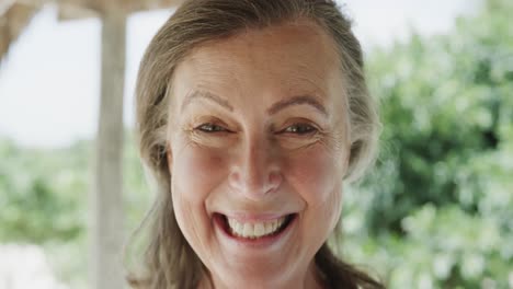 Porträt-Einer-Glücklichen-älteren-Kaukasischen-Frau,-Die-Am-Strand-Lächelt,-In-Zeitlupe