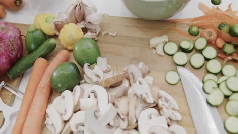 Overhead-view-of-bowls-and-various-raw-vegetables-on-kitchen-countertop,-slow-motion