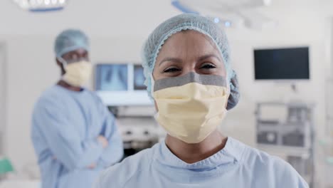 Portrait-of-happy-diverse-surgeons-with-face-masks-in-operating-room-in-slow-motion,-unaltered
