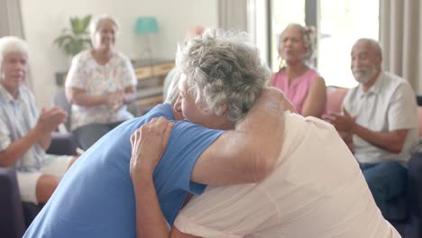Diverse-seniors-talking-and-embracing-in-emotional-group-therapy-session,-unaltered,-slow-motion