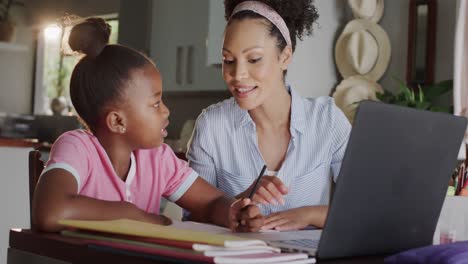 Glückliche-Afroamerikanische-Mutter-Und-Tochter,-Die-Laptop-Benutzen-Und-Gemeinsam-Hausaufgaben-Machen,-Zeitlupe