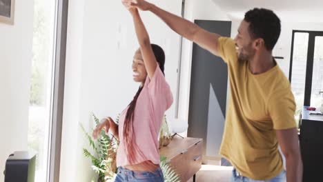 Glückliches-Afroamerikanisches-Paar-Hält-Händchen-Und-Tanzt-Im-Wohnzimmer,-In-Zeitlupe