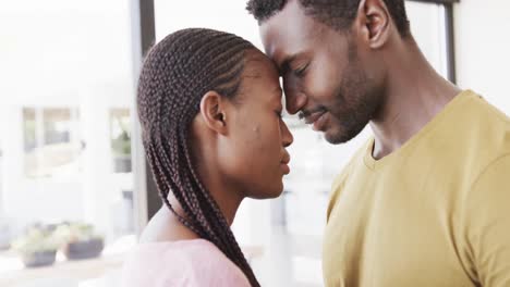 Glückliches-Afroamerikanisches-Paar,-Das-Zu-Hause-Lächelt-Und-Mit-Geschlossenen-Augen-Köpfe-Berührt,-In-Zeitlupe