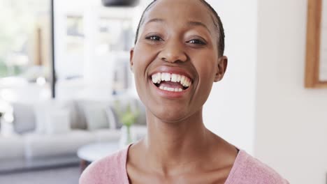 Porträt-Einer-Glücklichen-Afroamerikanischen-Frau,-Die-Zu-Hause-Im-Wohnzimmer-Lacht,-In-Zeitlupe