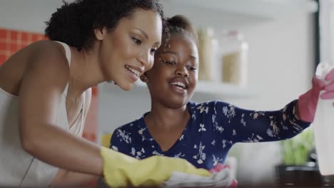 Glückliche-Afroamerikanische-Mutter-Und-Tochter-Putzen-Gemeinsam-Die-Küche,-Zeitlupe