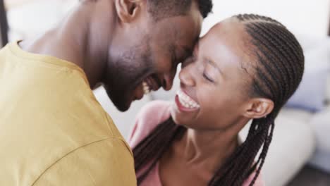 Glückliches-Afroamerikanisches-Paar,-Das-Im-Wohnzimmer-Lacht-Und-Umarmt,-In-Zeitlupe