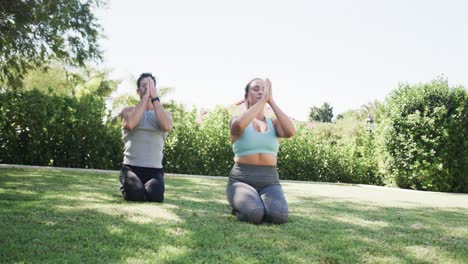 Happy-caucasian-couple-practicing-yoga-meditation-in-sunny-garden,-slow-motion