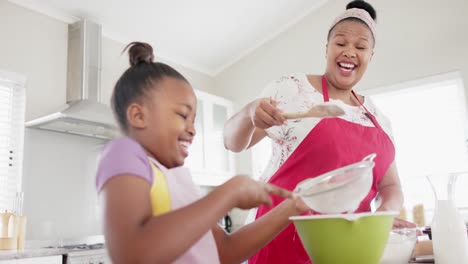 Happy-unaltered-african-american-mother-and-daughter-baking-in-kitchen,-in-slow-motion