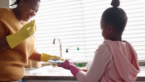 Glückliche-Afroamerikanische-Mutter-Und-Tochter,-Die-In-Der-Küche-Geschirr-Spülen,-Zeitlupe